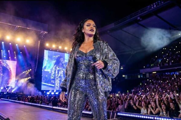Rihanna performing live on stage during a concert in 2026, highlighting her journey from global pop star to billionaire business leader